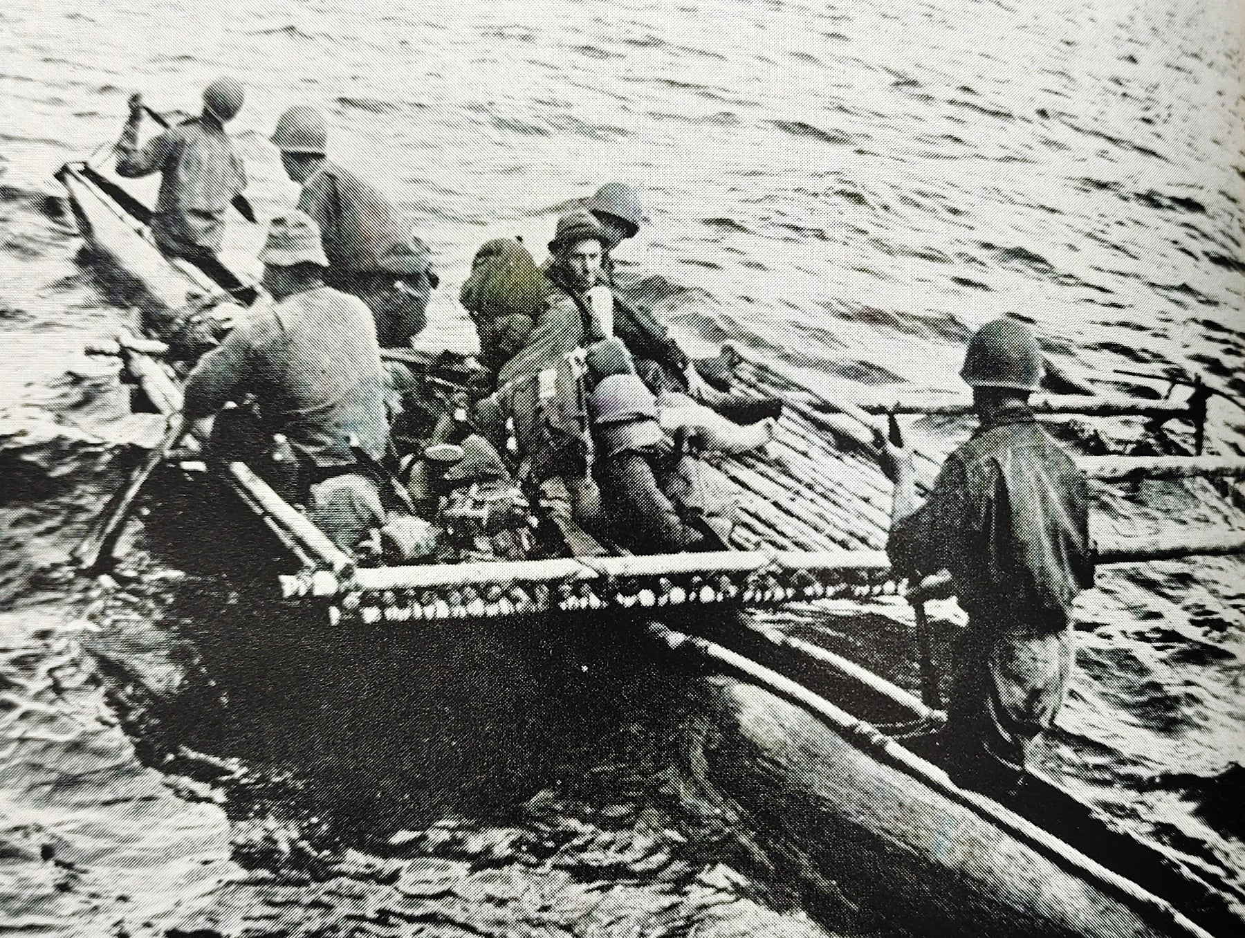 Image of people on a raft/boat from the first edition of Robinson's The Fight for New Guinea (1943)